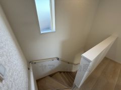 お子様も高齢の方も安心して上り下りができる手摺がついた安心設計です。 階段には小窓を配置しました。日中でも暗くなりがちな階段下が明るくなり安全ですね。