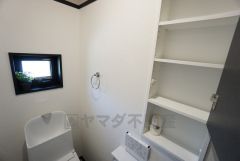 2階トイレには収納棚と小窓付き。