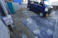 現地（2026年1月）撮影。 2号棟。 駐車スペースは2台分を確保（車種による）。マイカー用に、お客さま用に、余裕を持ってご利用いただけます。