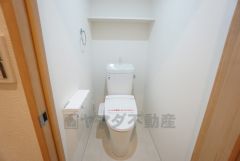 清潔感のあるトイレ。 上部には棚が備え付けられているのでストック品などの収納に便利ですね。