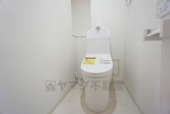ウォシュレット付きトイレです。トイレ後方にはトイレットペーパーの予備などを収納できる棚が付いています。